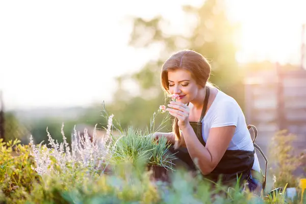 Practique la jardinería consciente tomándose el tiempo para oler las flores.